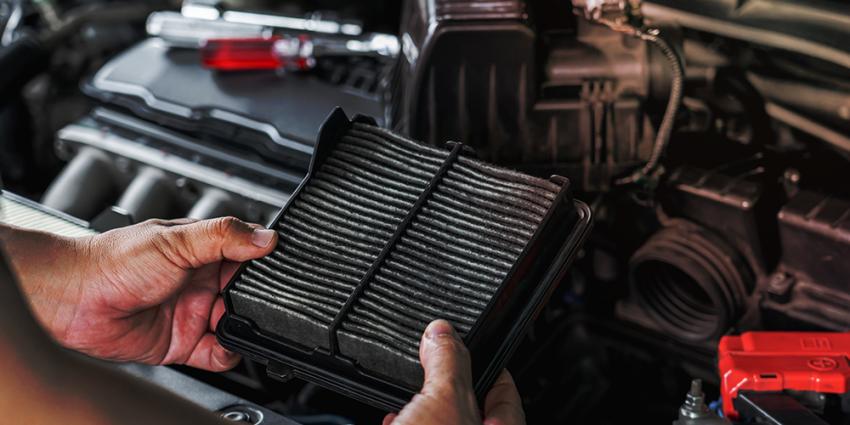 Auto mechanic inspects a vehicle filter