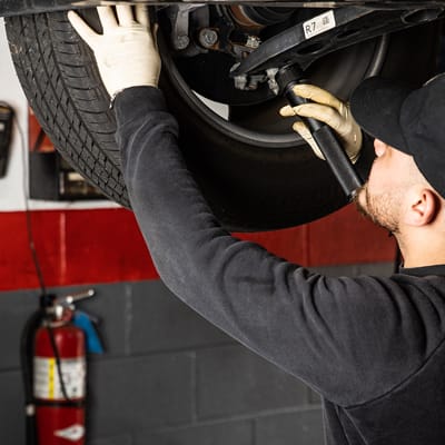 Auto repair technician insects a tire in Clarendon