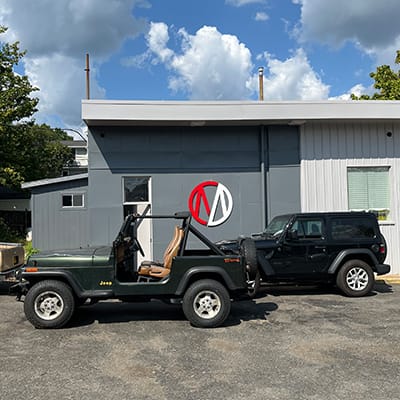 Two Jeeps parked at Metro Motor auto repair shop in Clarendon, VA