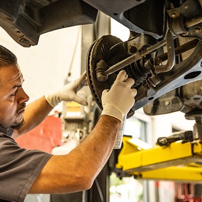 Auto repair technician works under a vehicle in Old Town Alexandria