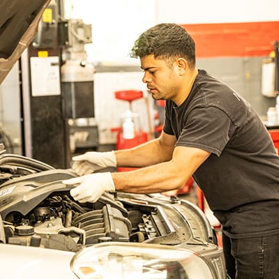 Auto repair technician works under the hood in Old Town Alexandria