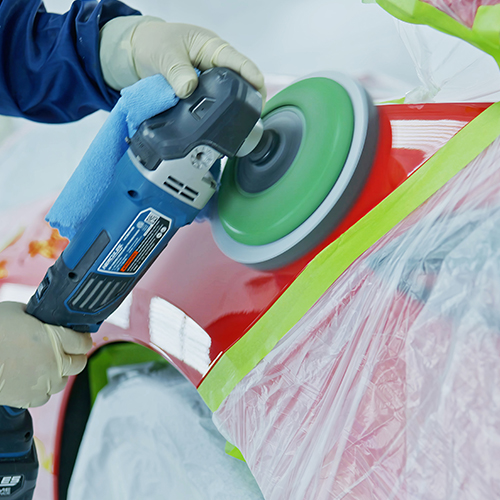 A paint specialist at Metro Motor collision repair buffs a newly restored vehicle