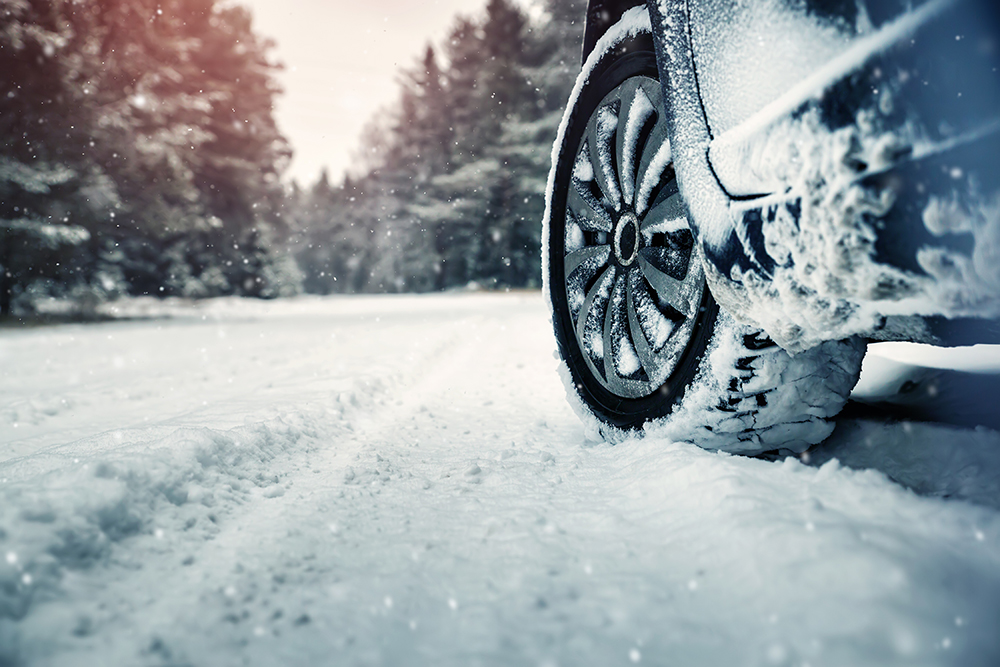 Car drives with snow tires on an icy road in winter