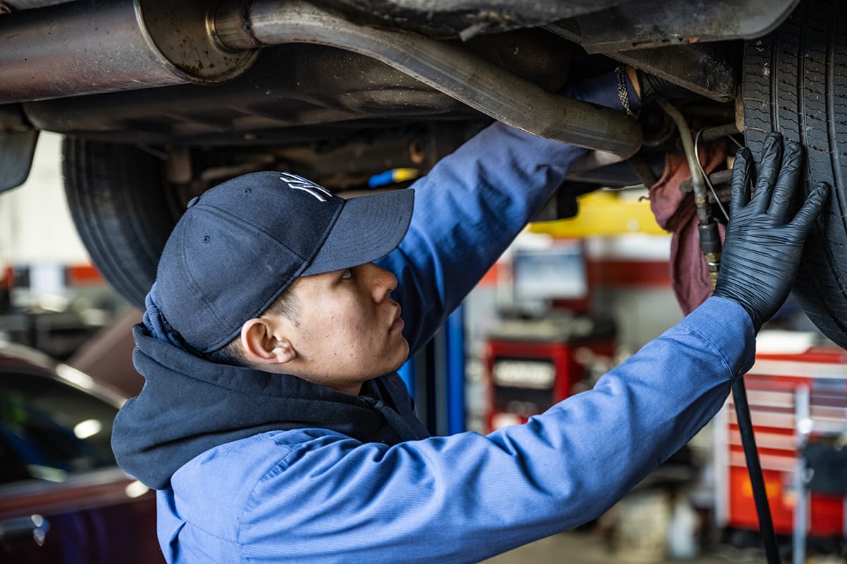 A Metro Motor technician inspects under a vehicle at an auto repair center in D.C.