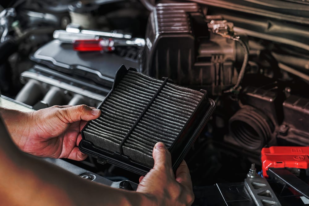Auto mechanic inspects a vehicle filter