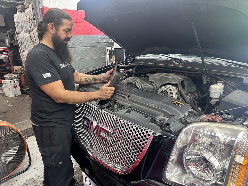 Auto repair technician performs GMC check engine light diagnostics