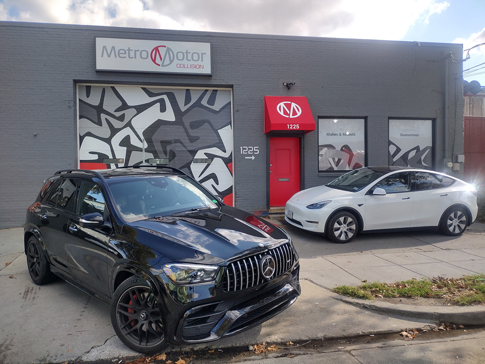 Two repaired vehicles are parked in front of the Metro Motor collision repair shop in Washington, DC