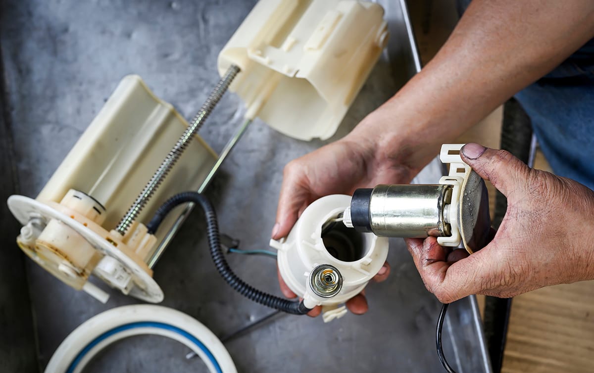 Auto repair technician dismantles a failing fuel pump