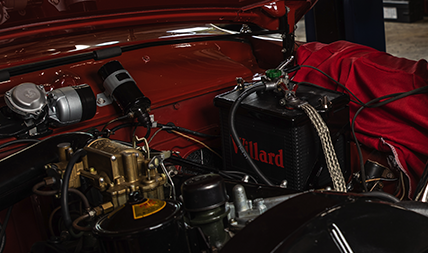 Detail under the hood of a car battery ready for testing in an auto repair shop.