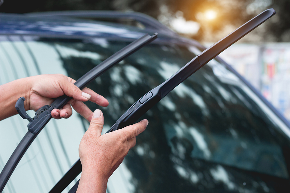 Man inspects windshield wipers