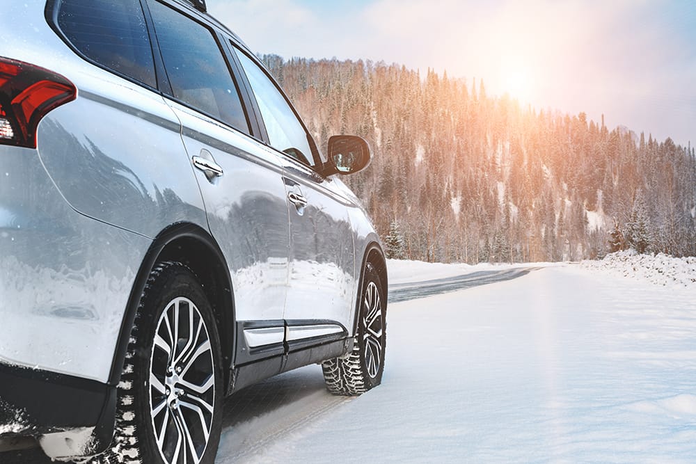 SUV drives across a winter scene