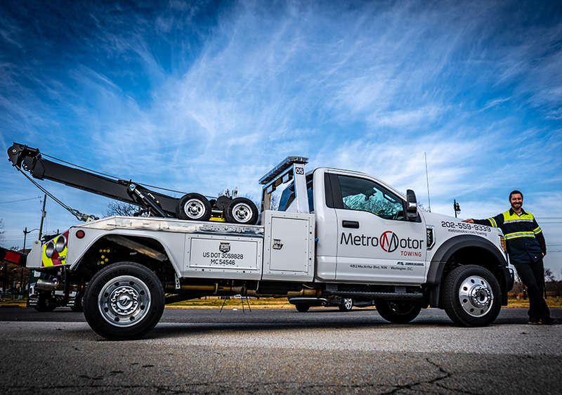 Tow truck driver stands next to his Virginia towing truck