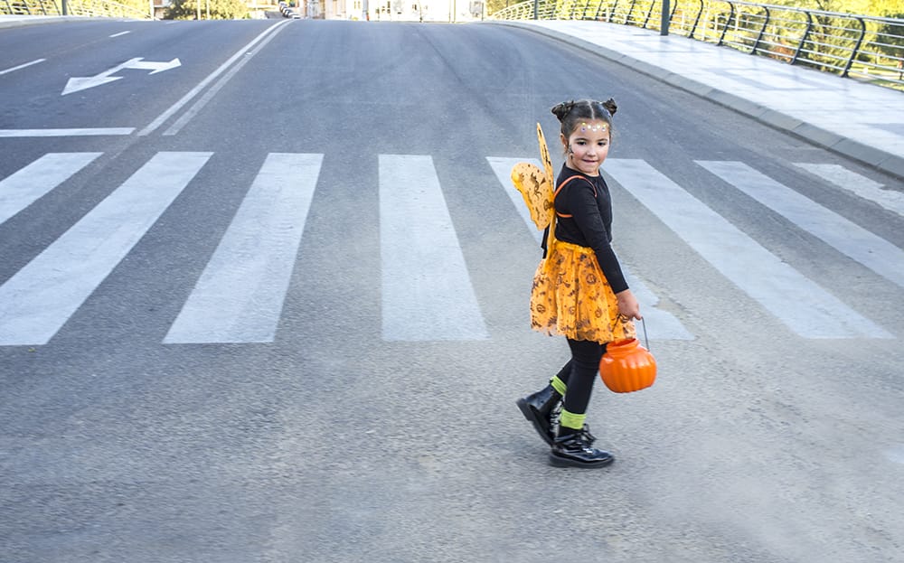 Child crosses the street on Halloween