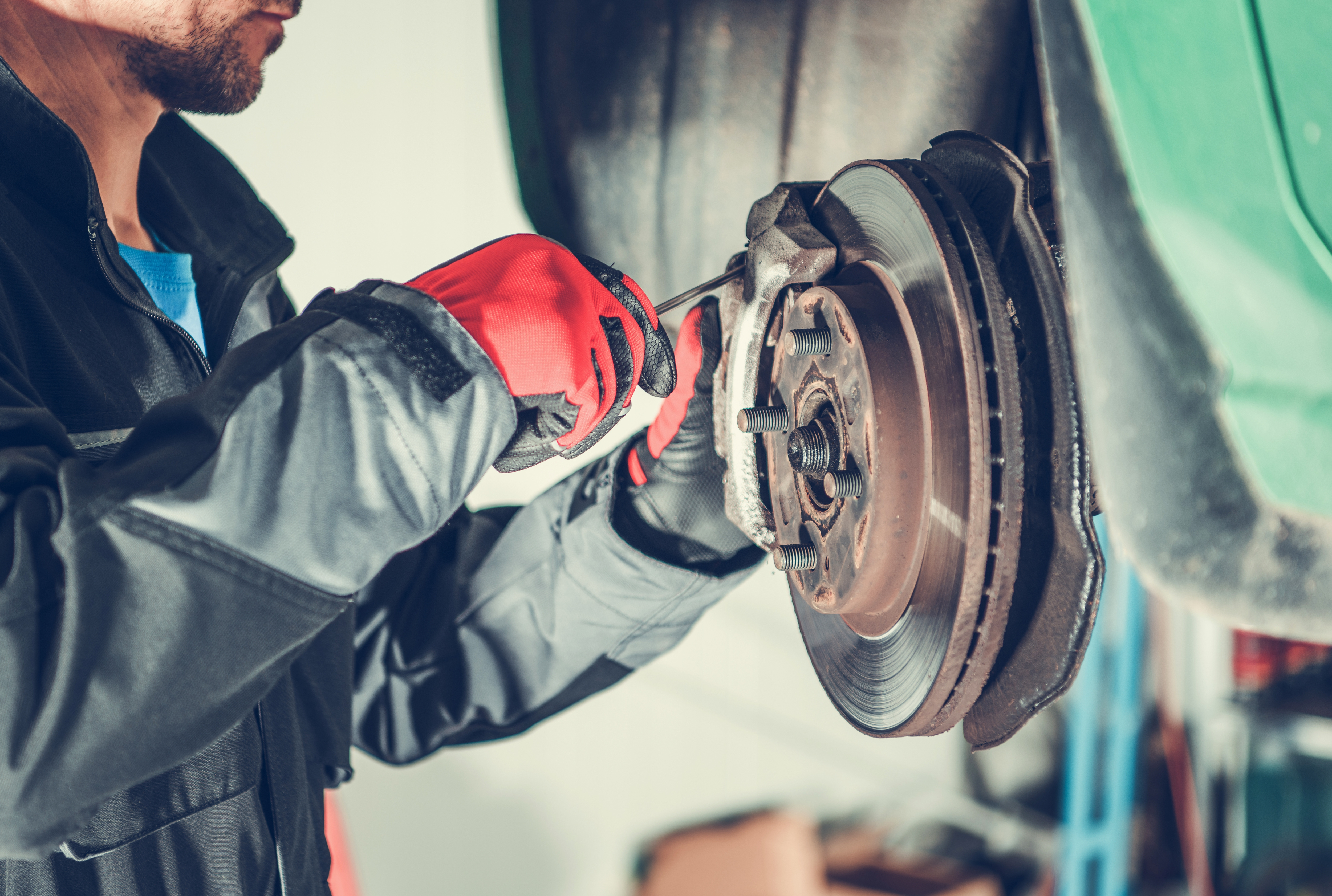 Mechanic checks brake system in wheels of car