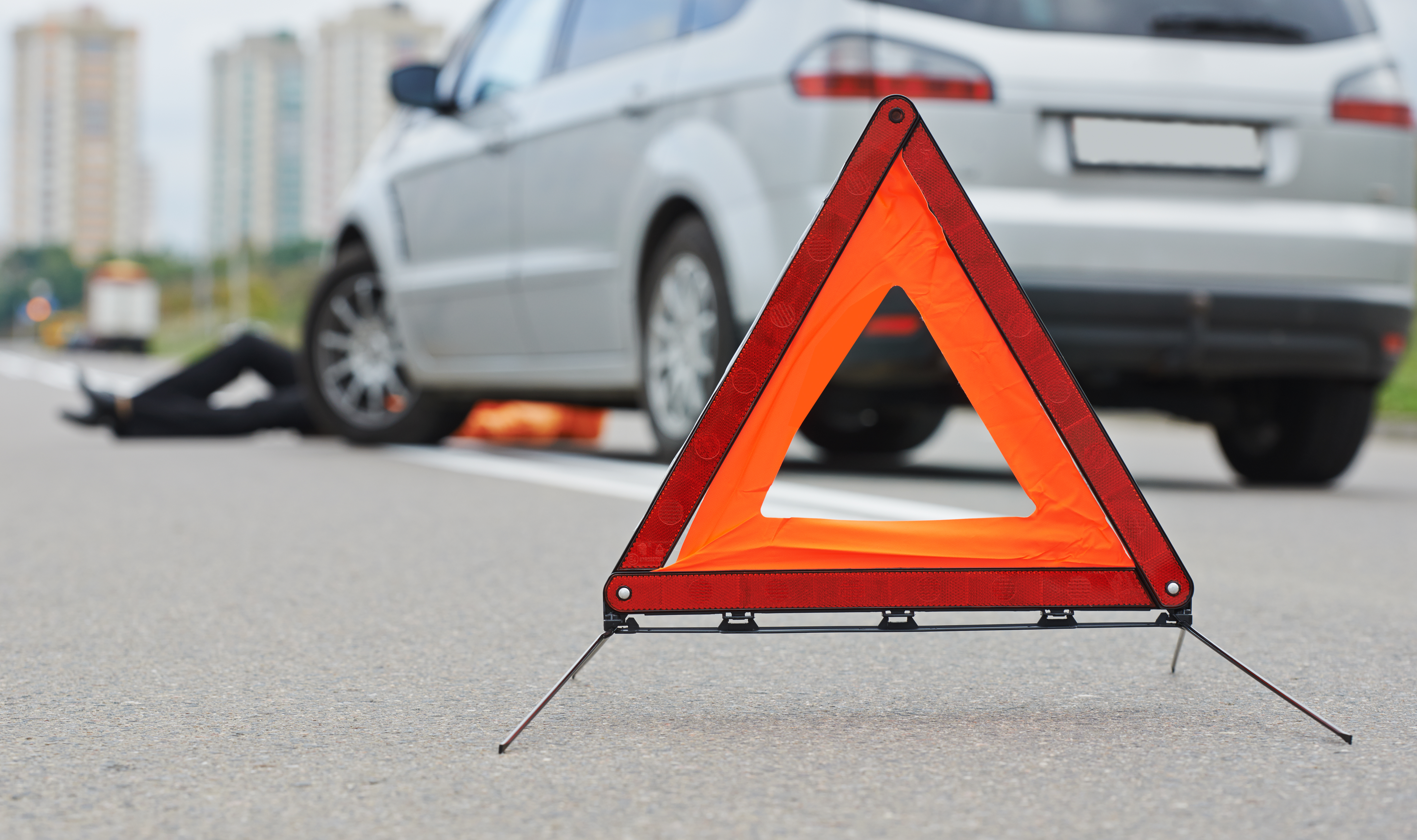 Pop up roadside warning cones with an out of focus car on the side of the road
