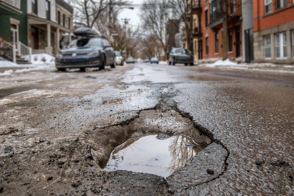 Deep pothole in a city neighborhood street