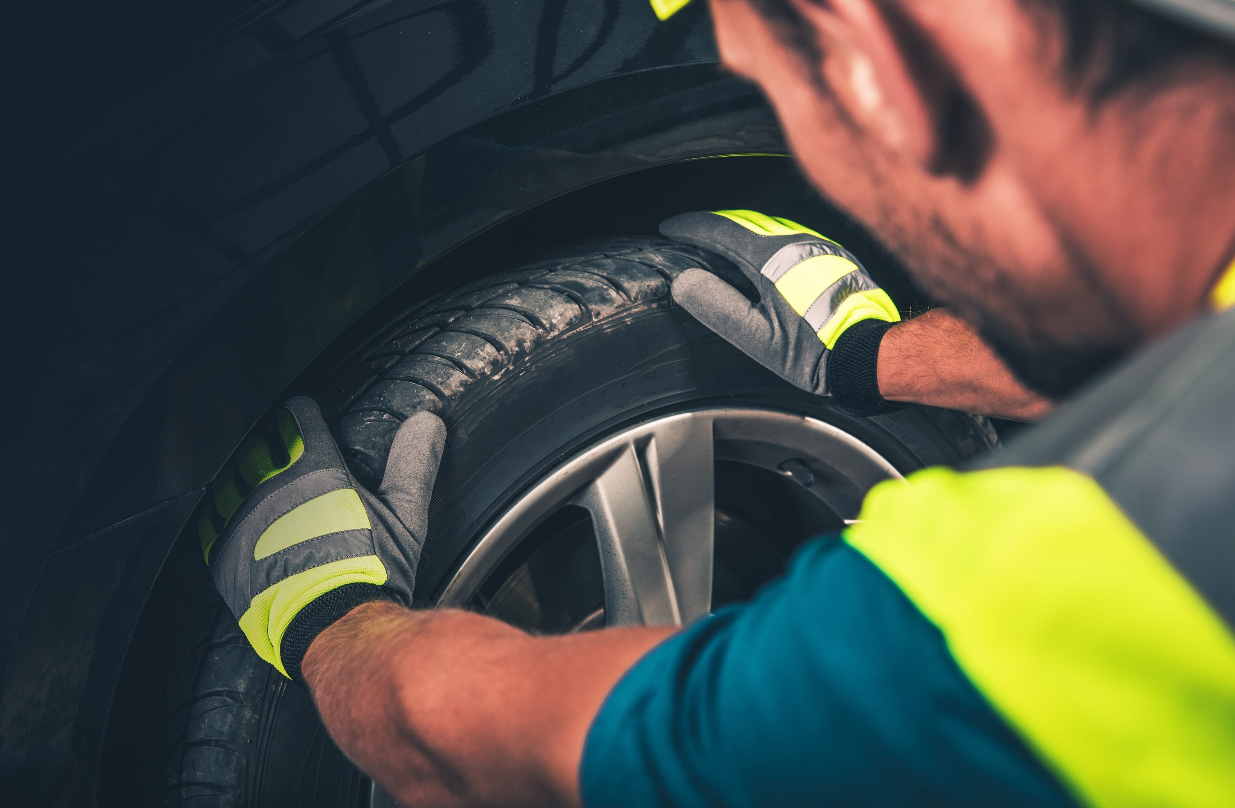 Man prepares tire for rotation