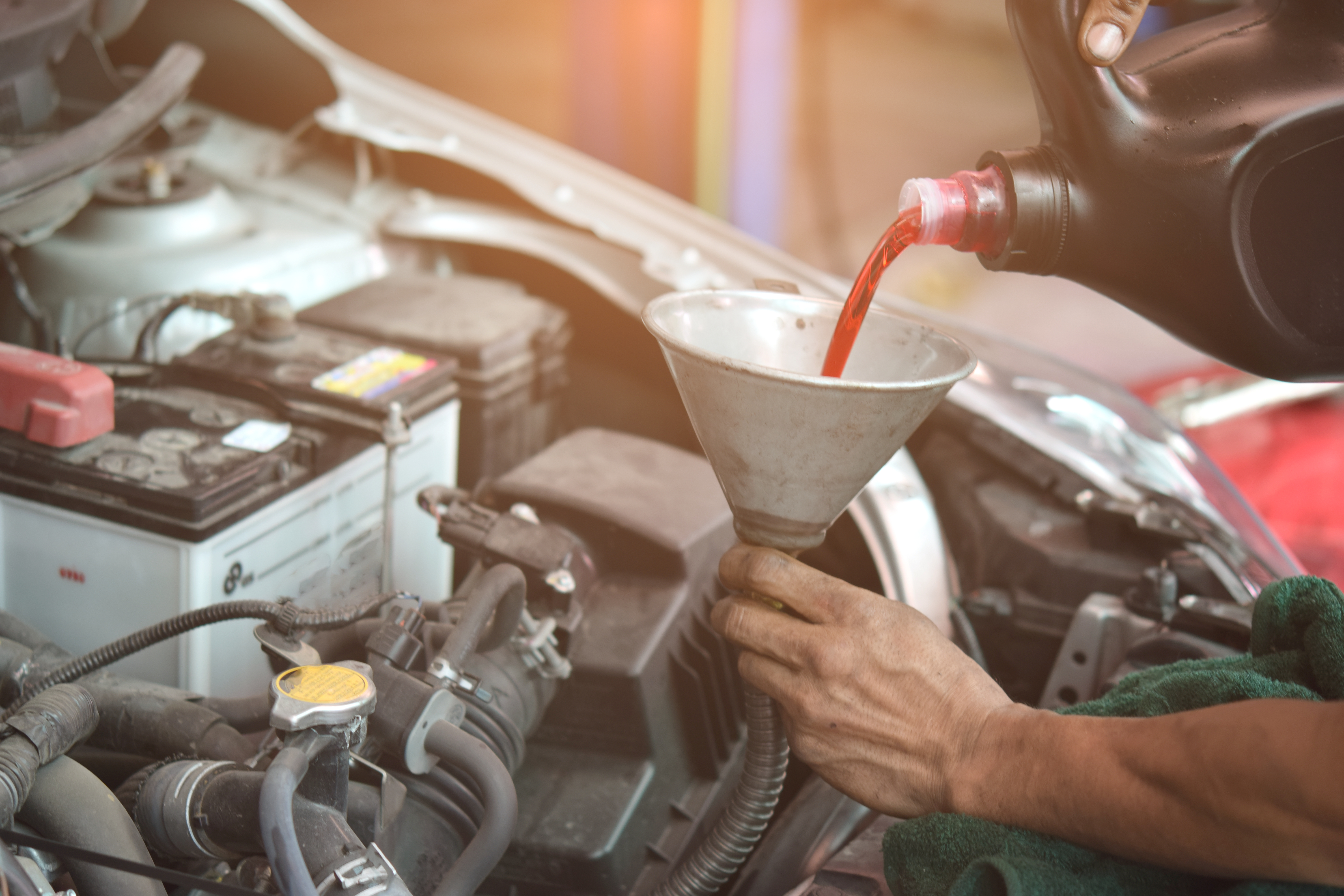 Pouring fluid into a car engine spout