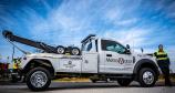 Tow truck driver stands next to his Virginia towing truck
