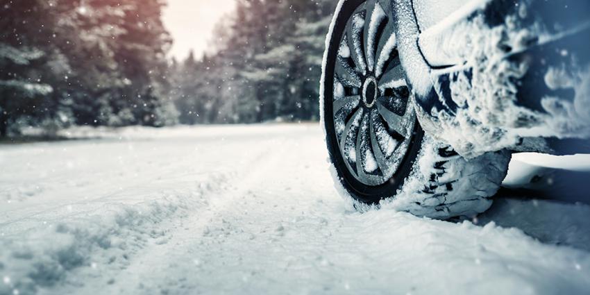 Car drives with snow tires on an icy road in winter