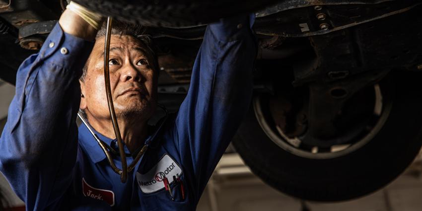Auto repair technician works under a vehicle in Washington DC