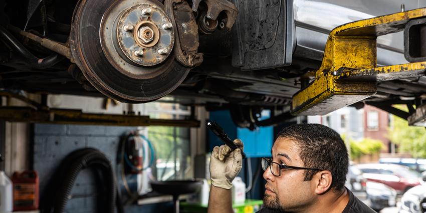 Metro Motor auto repair technician inspects a vehicle's brakes
