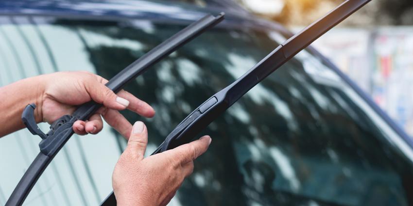 Man inspects windshield wipers