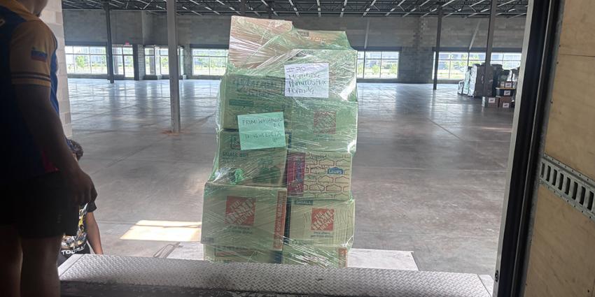 Pallets of donated goods are loaded onto a Metro Motor Auto Supply truck.