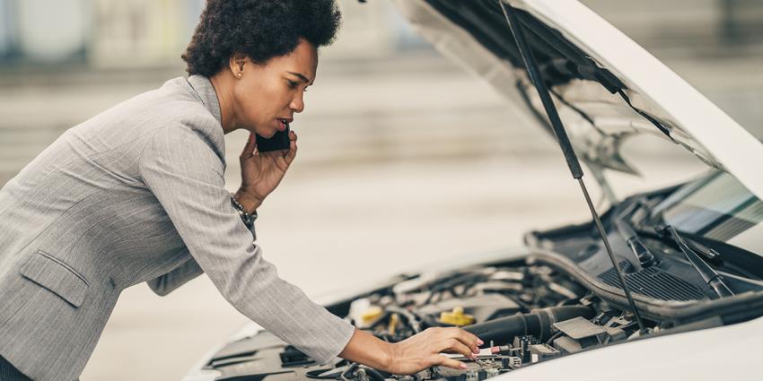 Woman inspects engine after hearing strange noises under the hood