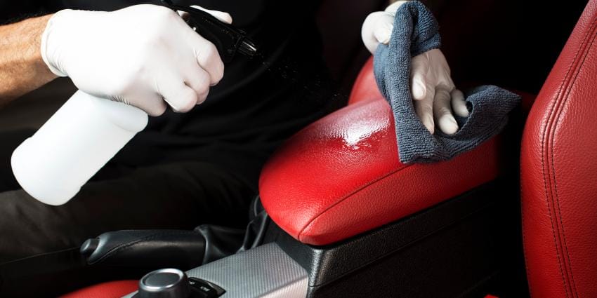 Red and black car interior being cleaned 