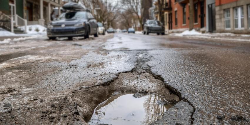 Deep pothole in a city neighborhood street