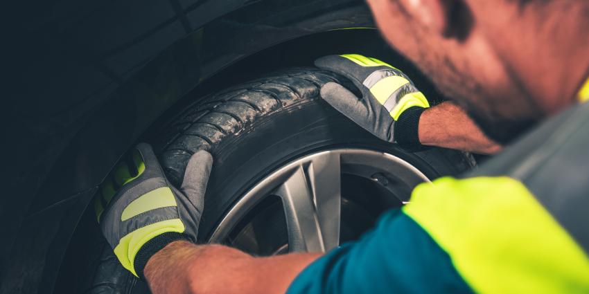 Man prepares tire for rotation