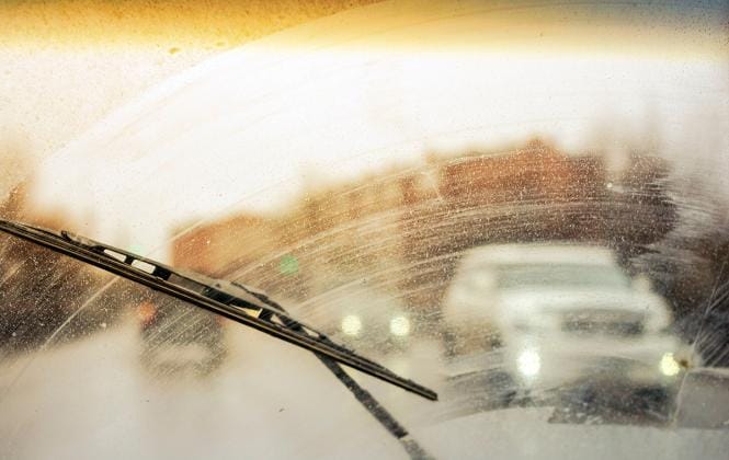 View through a dirty windshield of failing windshield wipers
